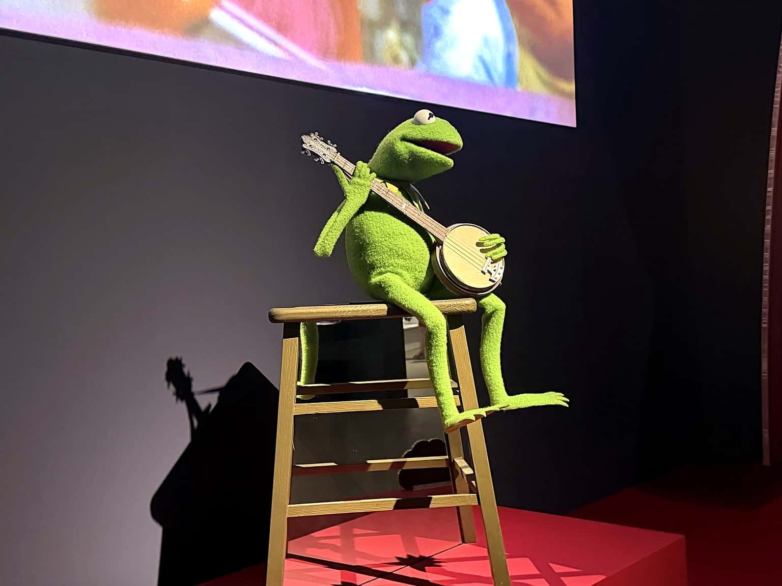 Kermit the Frog sitting with his banjo at the Jim Henson exhibition at GOMA
